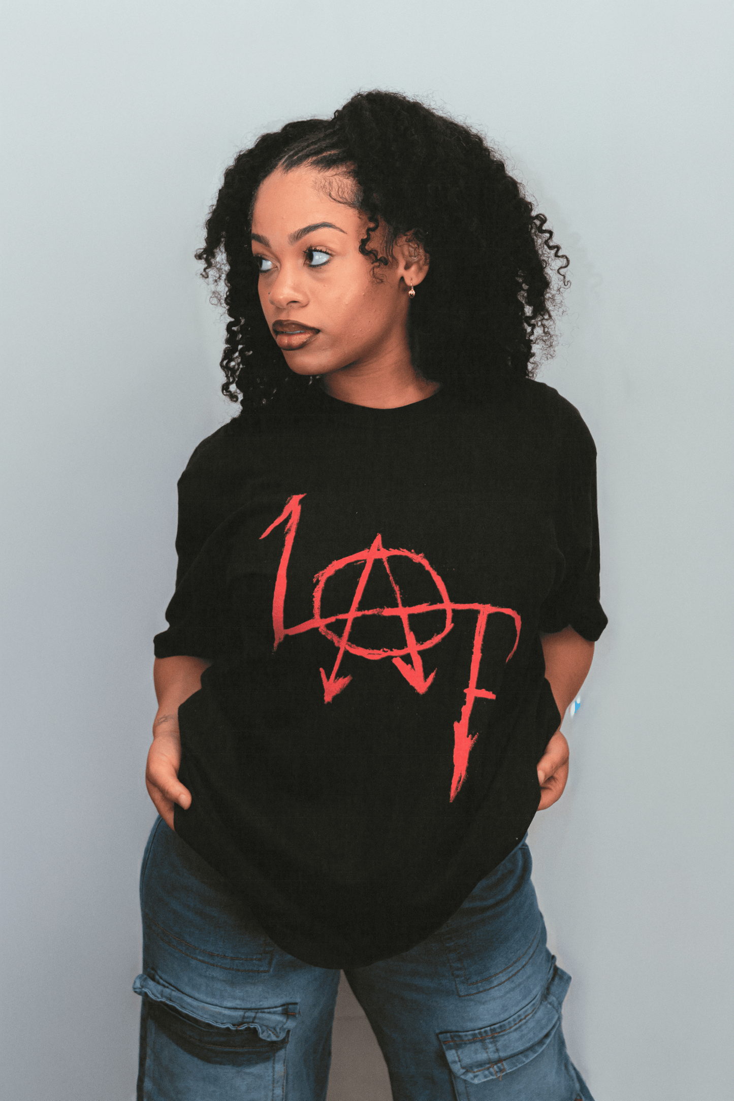 Person wearing a black t-shirt with red logo against a plain background