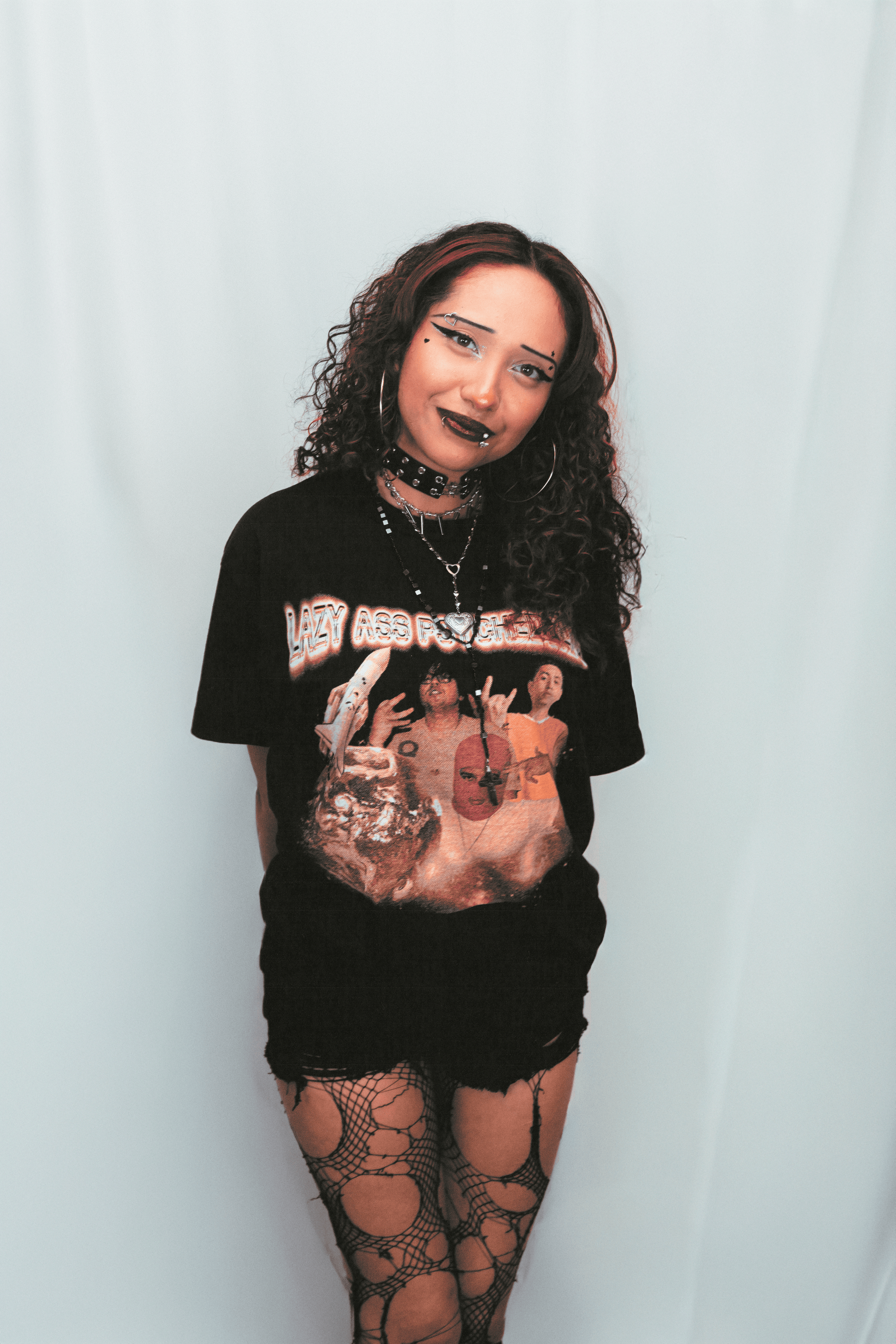 Person wearing a black t-shirt with a graphic design on a plain background